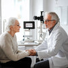 Elderly woman receiving compassionate care from an optometrist in a bright clinic setting.