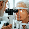 An eye doctor performing an eye examination on an elderly woman using a slit lamp for vision assessment.